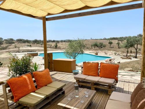 格兰杜拉Mama Adama - Alpaca Farm & Hotel的一个带桌椅的庭院和一个游泳池