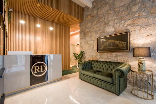 波尔图Ribeira Douro Hotel的客厅设有绿色沙发和石墙