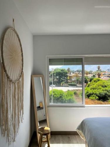 多列毛利诺斯NIEUW: Bello Horizonte, house by the sea的一间卧室设有一张床、一个窗口和一面镜子