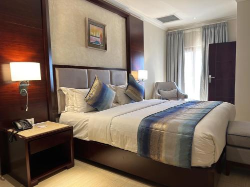 卢萨卡Grand Palace Hotel Lusaka的一间设有大床和窗户的酒店客房