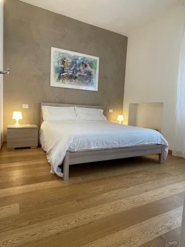 维罗纳Sarah Apartment Verona Fiera的一间卧室配有一张带两盏灯的大型白色床。