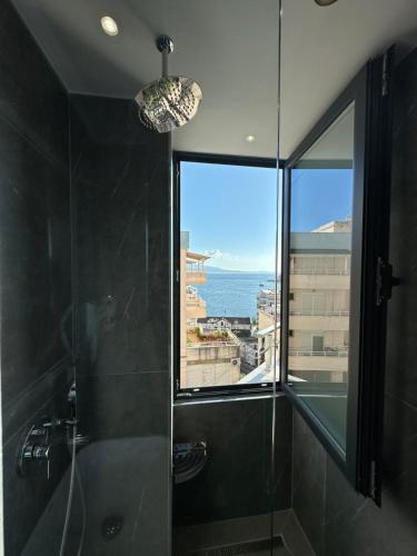 萨兰达Villa Idrizi的带淋浴的浴室,享有海景。