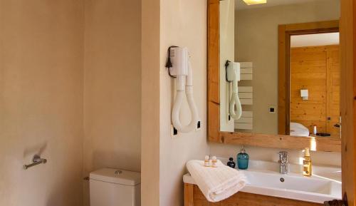 莱德萨阿尔卑斯Vacancéole - Résidence Cortina的一间带水槽和镜子的浴室以及一部电话