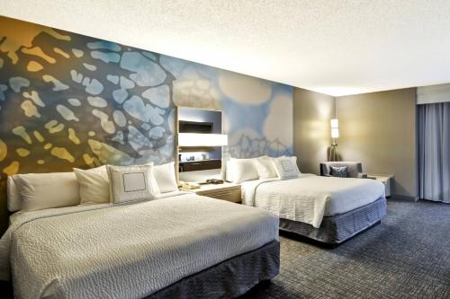 休斯顿休斯顿I-10州际公路西/能源走廊万怡酒店的酒店客房设有两张床,墙上挂有绘画作品