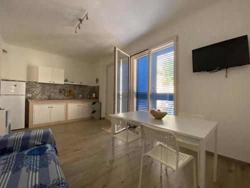 CampomarinoGemma Mediterranea的厨房以及带白色桌椅的用餐室。