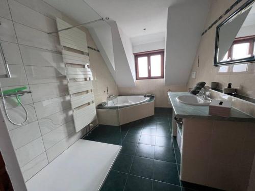 斯特哲兹Appartement Stotzheim La Romaine的大型浴室设有2个水槽和淋浴。
