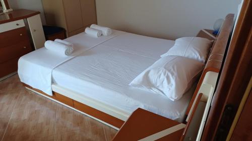 希马拉Mairymairy的配有白色床单和枕头的宿舍间内的一张床位