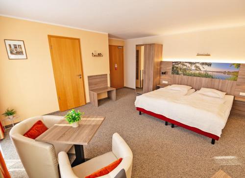 瓦伦Hotel Zur Sonne的酒店客房带一张床、一张桌子和椅子
