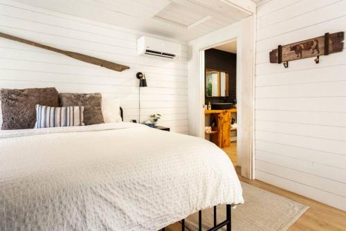 Mill VillageThe Old Kettle Cabin with Hot Tub的一间白色卧室,配有床和门廊