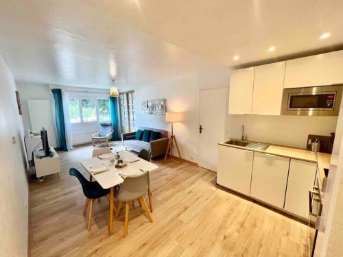 安纳马斯Le Genevois - Parking gratuit的厨房以及带桌椅的起居室。