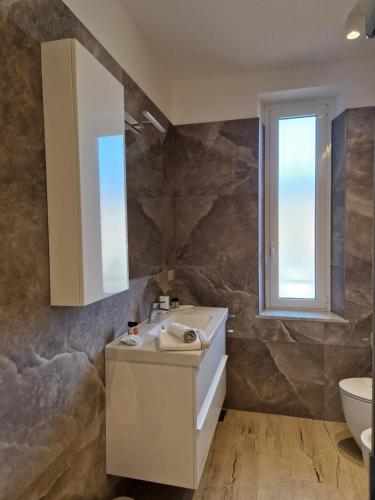 拉瓦尼亚Ca' da Bianca的一间带水槽和卫生间的浴室以及窗户。