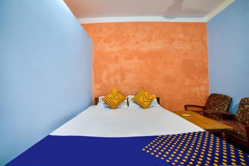 德奥加尔SPOT ON Shashi Prabha Palace的一间卧室配有一张床和两把椅子