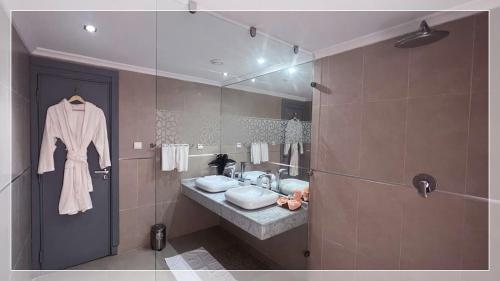 阿尤恩Hotel Al Massira的一间带水槽和镜子的浴室