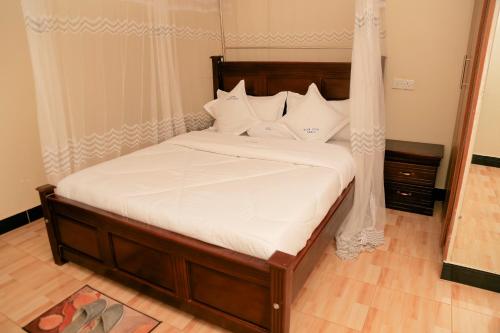 金贾Scindia Suites hotel的一张带白色床单和枕头的床