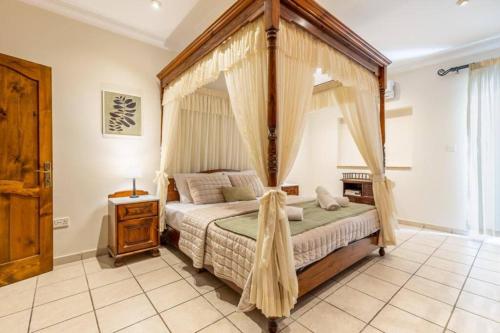 马尔萨斯卡拉Maisonette filled with Maltese charm in the south of Malta的一间卧室设有天蓬床和窗户。
