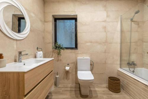 马尔萨斯卡拉Maisonette filled with Maltese charm in the south of Malta的一间带卫生间、水槽和镜子的浴室