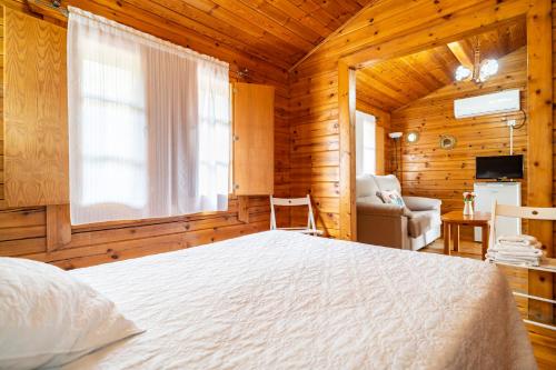 普拉多德尔雷多罗蒂亚果园农庄酒店的木制客房内的一间卧室,配有一张床