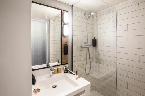 斯特拉斯堡宜必思斯特拉斯堡中心乐斯哈勒斯酒店的一间带水槽和玻璃淋浴的浴室