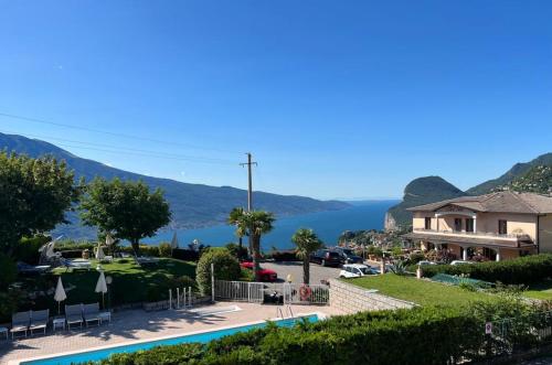 特雷莫西内Hotel Garni Bel Sito的享有带游泳池和房屋的度假村景色
