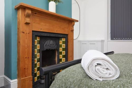 莱斯特Timeless Elegance 4-Bed Victorian Charm的一张铺在壁炉旁床上的毯子