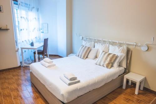 罗马Cozy flat with terrace at Trastevere train station的卧室配有带毛巾的大型白色床