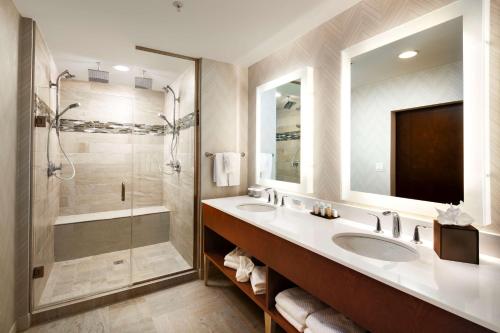 阿马里洛阿马里洛市中心大使套房酒店的一间带两个盥洗盆和淋浴的浴室