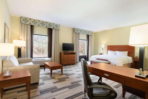 伯明翰伯明翰机场区汉普顿套房酒店的配有一张床和一张书桌的酒店客房