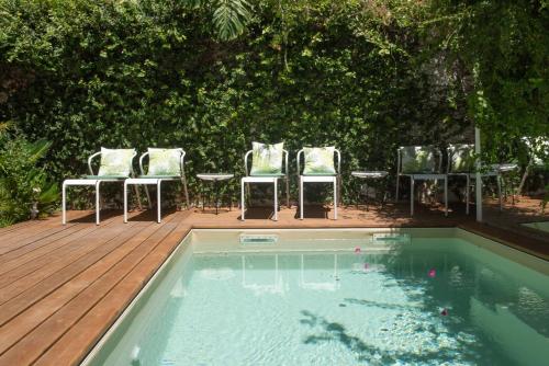 里斯本巴朗住宿加早餐旅馆的一组椅子和一个带甲板的游泳池