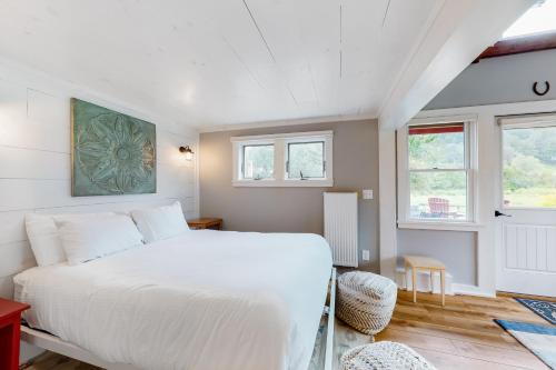 Pomfret Bungalow的卧室配有白色的床和2扇窗户。