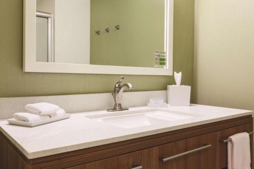 大学城希尔顿惠庭酒店的一间带水槽和镜子的浴室