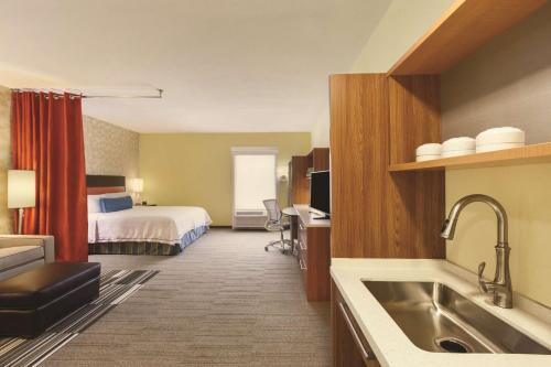 大学城希尔顿惠庭酒店的大型酒店客房设有床和厨房