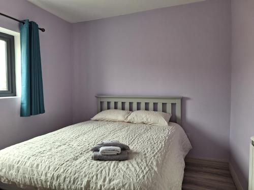 贝尔马利特Teach Aindí (newly renovated cottage)的一间卧室配有一张床,床上有毛巾