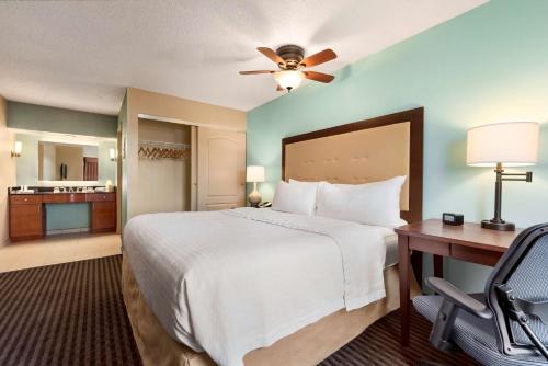 希利亚德哥伦布希利亚德希尔顿惠庭套房酒店的酒店客房设有一张大床和一张书桌。