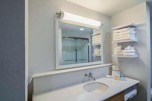 理查森达拉斯/理查森汉普顿酒店及套房的浴室配有盥洗盆、镜子和毛巾