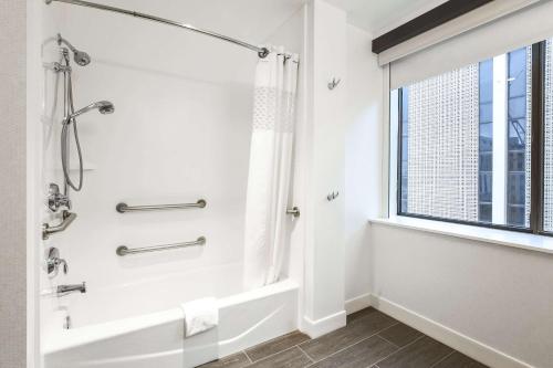 达拉斯达拉斯市中心汉普顿酒店及套房的带淋浴的浴室和窗户。