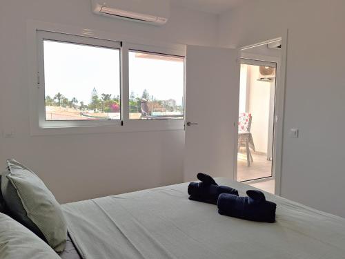 马斯帕洛马斯Joya de Iguazu - Centrum Playa del Inglés的白色的卧室设有床和窗户