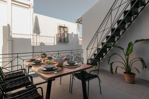 罗希姆诺Soleil boutique house with terrace的楼梯阳台的桌椅