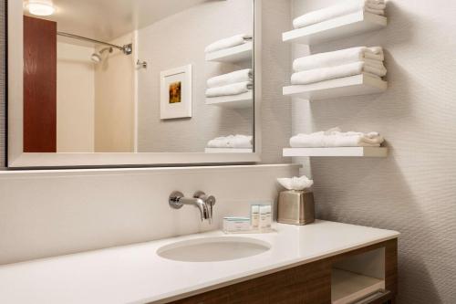 丹佛丹佛樱桃溪汉普顿旅馆及套房酒店的浴室配有盥洗盆、镜子和毛巾