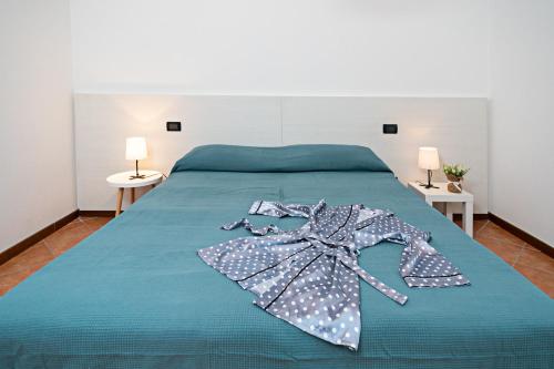 科斯特曼诺VILLA IDA - Regarda Travel的一张带蓝色棉被的床,上面有连衣裙