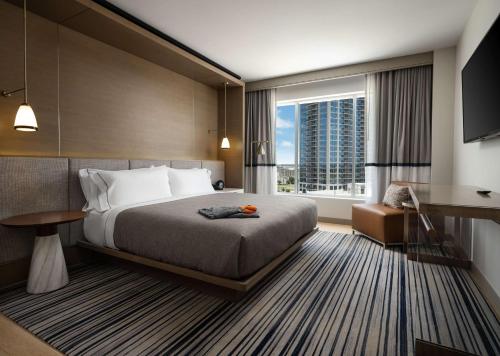 弗赖拉辛Canopy By Hilton Dallas Frisco Station的酒店客房设有一张床和一个大窗户