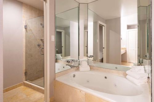 达拉斯达拉斯林肯中心希尔顿酒店的白色的浴室设有浴缸和淋浴。