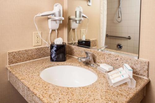 埃尔帕索Hilton Garden Inn El Paso University的浴室柜台配有水槽和电话