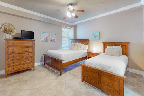 彭萨科拉海滩Sans Souci 303的一间卧室配有两张床和吊扇