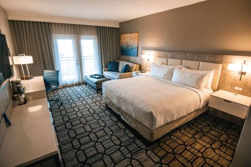 拉伯克Doubletree By Hilton Lubbock - University Area的酒店客房设有一张大床和一张沙发。