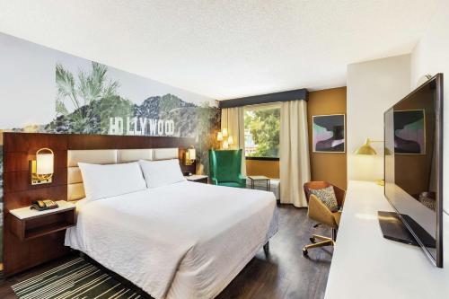 洛杉矶洛杉矶/好莱坞希尔顿花园酒店的一间酒店客房,配有一张床和一台电视