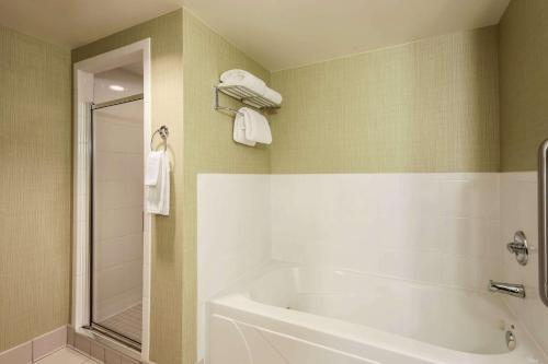 芝加哥芝加哥/中途机场希尔顿花园旅馆的浴室配有白色浴缸和淋浴。