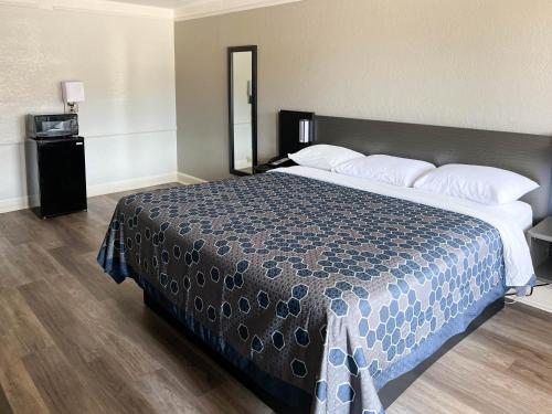 门罗梦露6号汽车旅馆的一间卧室配有一张带蓝色棉被的大床