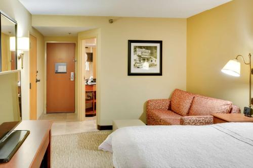 月球乡匹兹堡/机场希尔顿恒庭酒店的配有一张床和一把椅子的酒店客房
