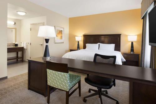 圣贝纳迪诺圣贝纳迪诺汉普顿套房酒店的酒店客房设有一张床、一张书桌和一间卧室