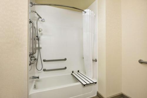 威奇托福尔斯赛克斯森特商城威奇托福尔斯汉普顿酒店的带淋浴和白色浴缸的浴室